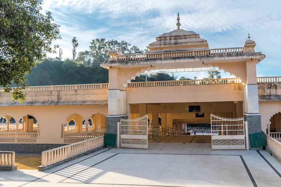 L’entrée d’un temple, avec une structure en forme de dôme, des portails en arc de cercle et une clôture qui l’entoure.