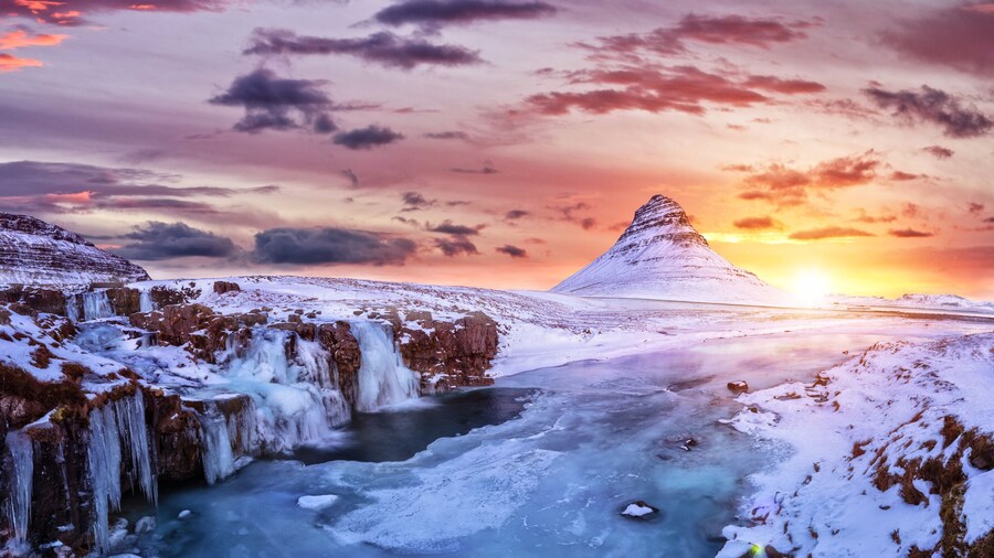 Kirkjufell mountain with frozen water falls in winter, Iceland.