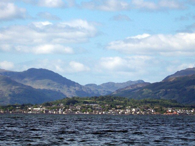 A lake with mountains in the background and a town on the opposite shore.