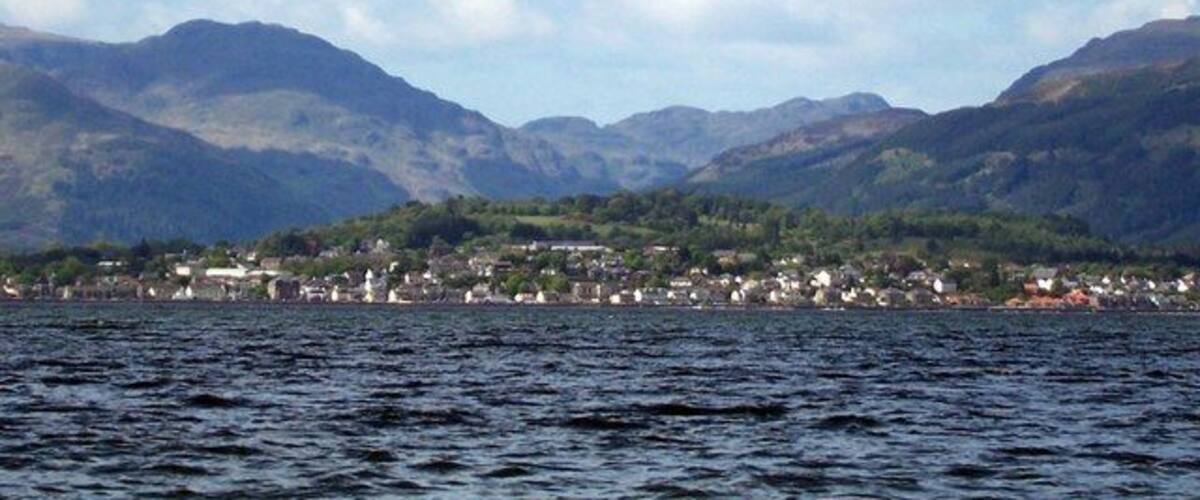 A lake with mountains in the background and a town on the opposite shore.