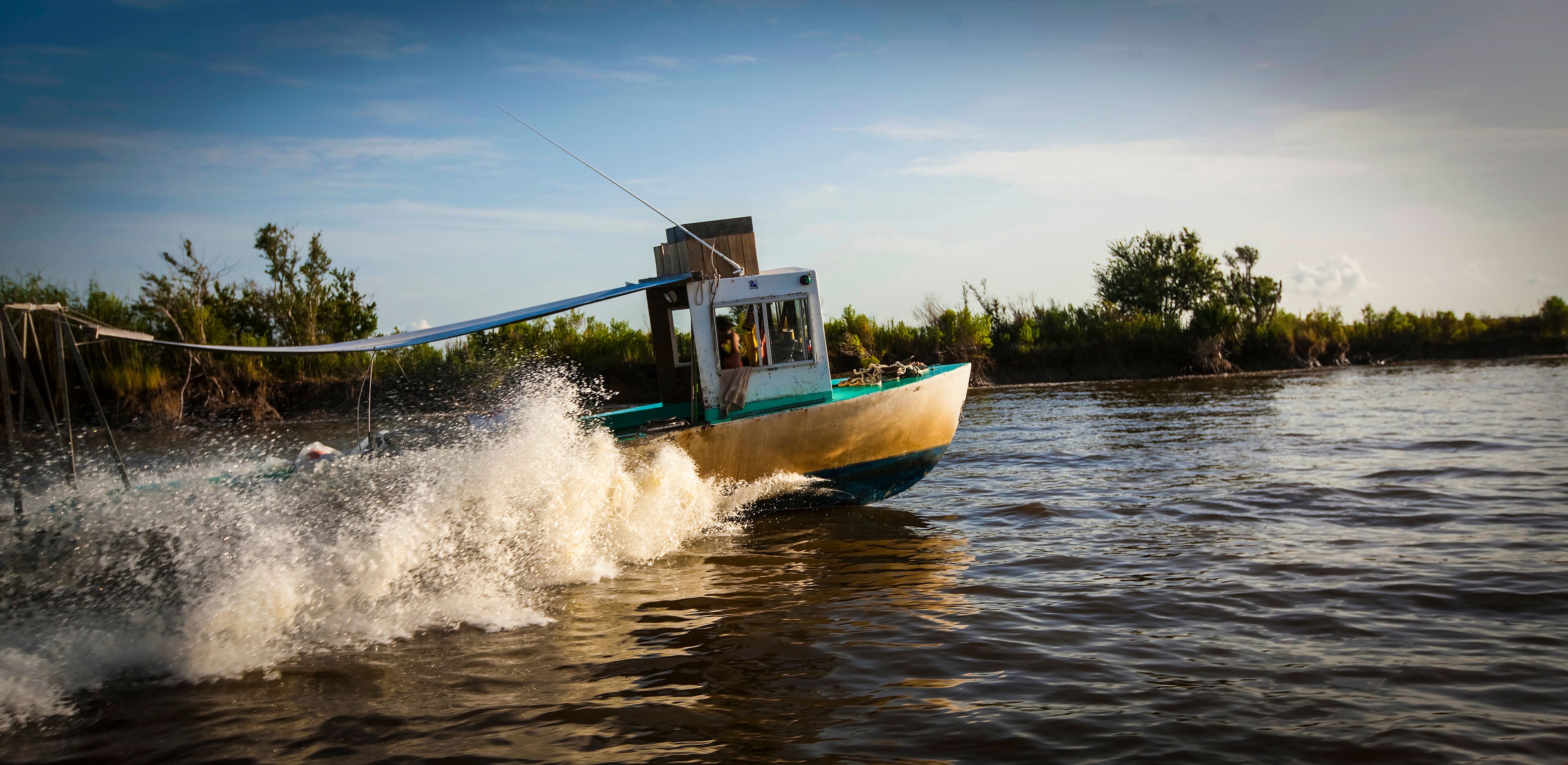 A small boat moving through water with a wake behind it.