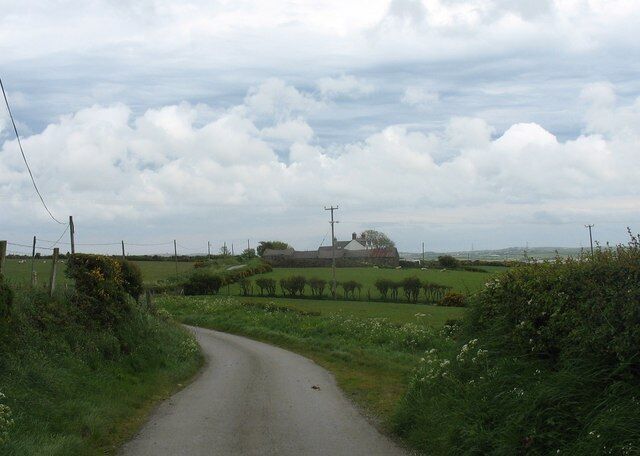 The Llanbabo to Rhosgoch road The roadside farmhouse is that of Tyddyn Bach (=small homestead). These country roads are excellent for walking or cycling. Even though it was a Bank Holiday Saturday the number of cars encountered averaged about three per hour.