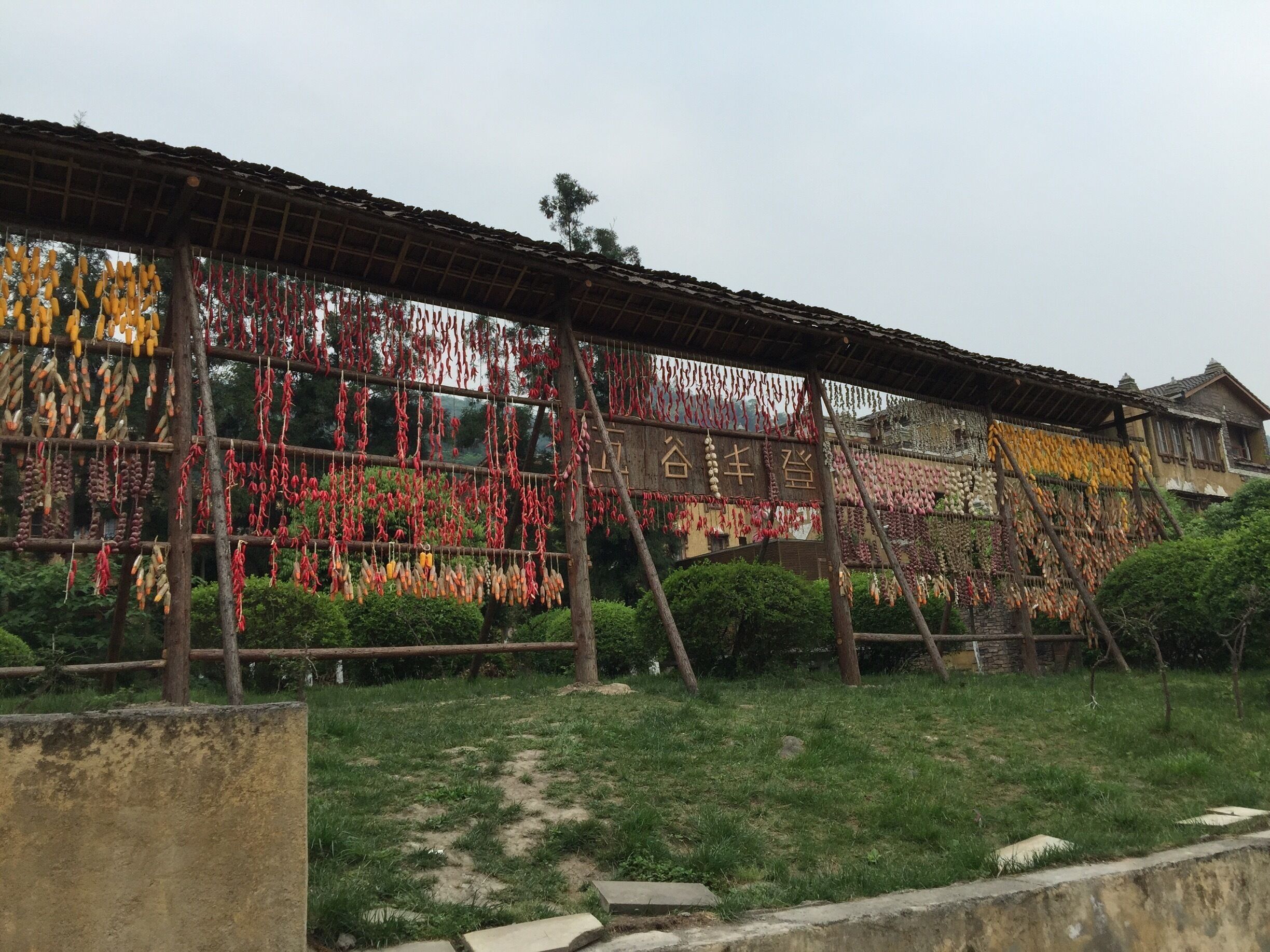 A traditional building with a wooden roof and walls, displaying various dried goods hanging in front.
