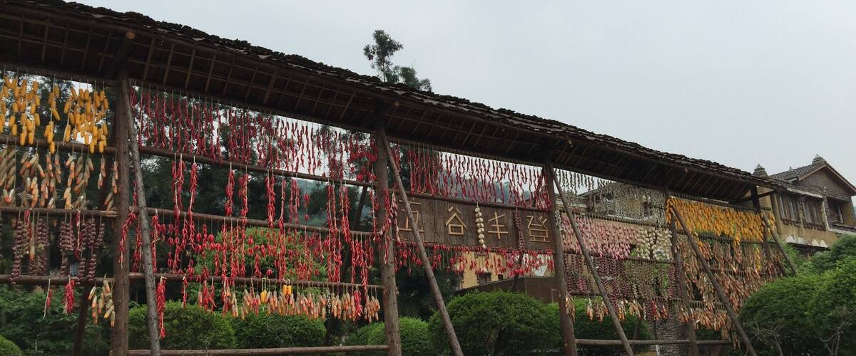 A traditional building with a wooden roof and walls, displaying various dried goods hanging in front.