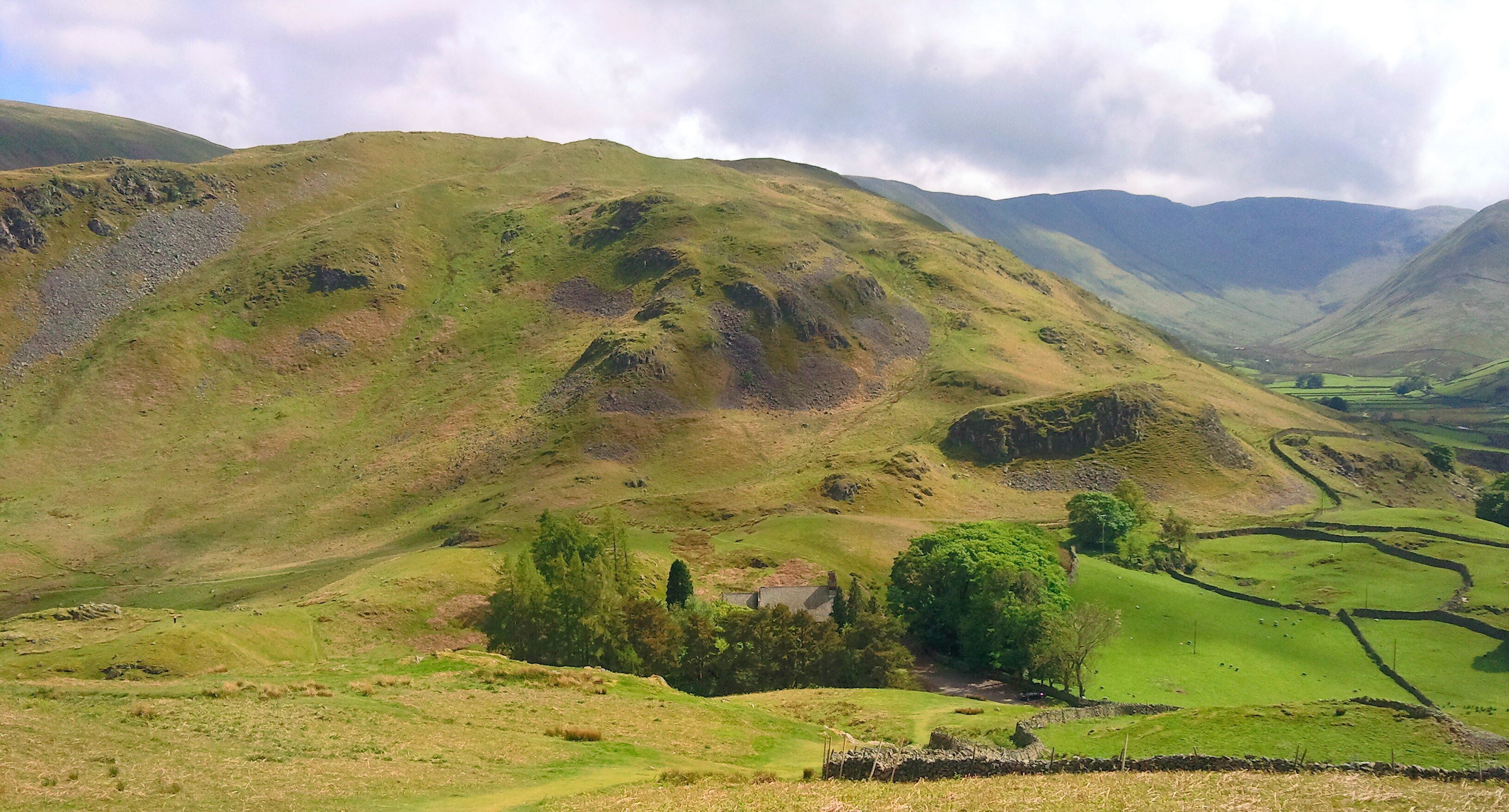 Rolling hills, a small house, and a valley.