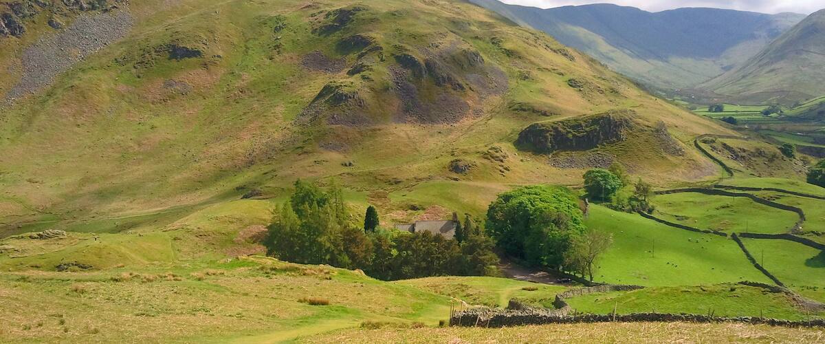 Rolling hills, a small house, and a valley.
