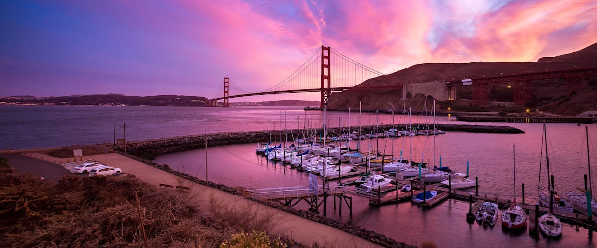 Il Ponte Dorato al tramonto con barche ormeggiate in una marina.