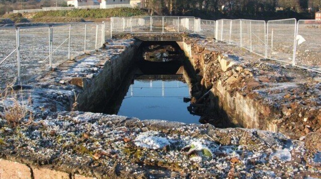 The Lade at Dalquhurn (exposed culvert). While the first half of the Lade (as reckoned from its intake), has long been exposed (1068180), this outflowing half has long been covered by buildings. At the time that this photograph was taken, the part of the Lade shown here had temporarily been exposed as a result of demolition work in Dalquhurn; it will presumably soon be covered again by subsequent construction work at that site. The houses in the background are in the Tontine area of Renton.