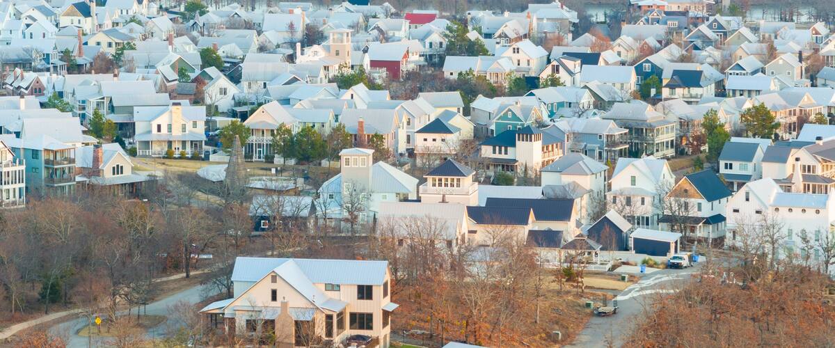 A residential area with houses and a river in the background.