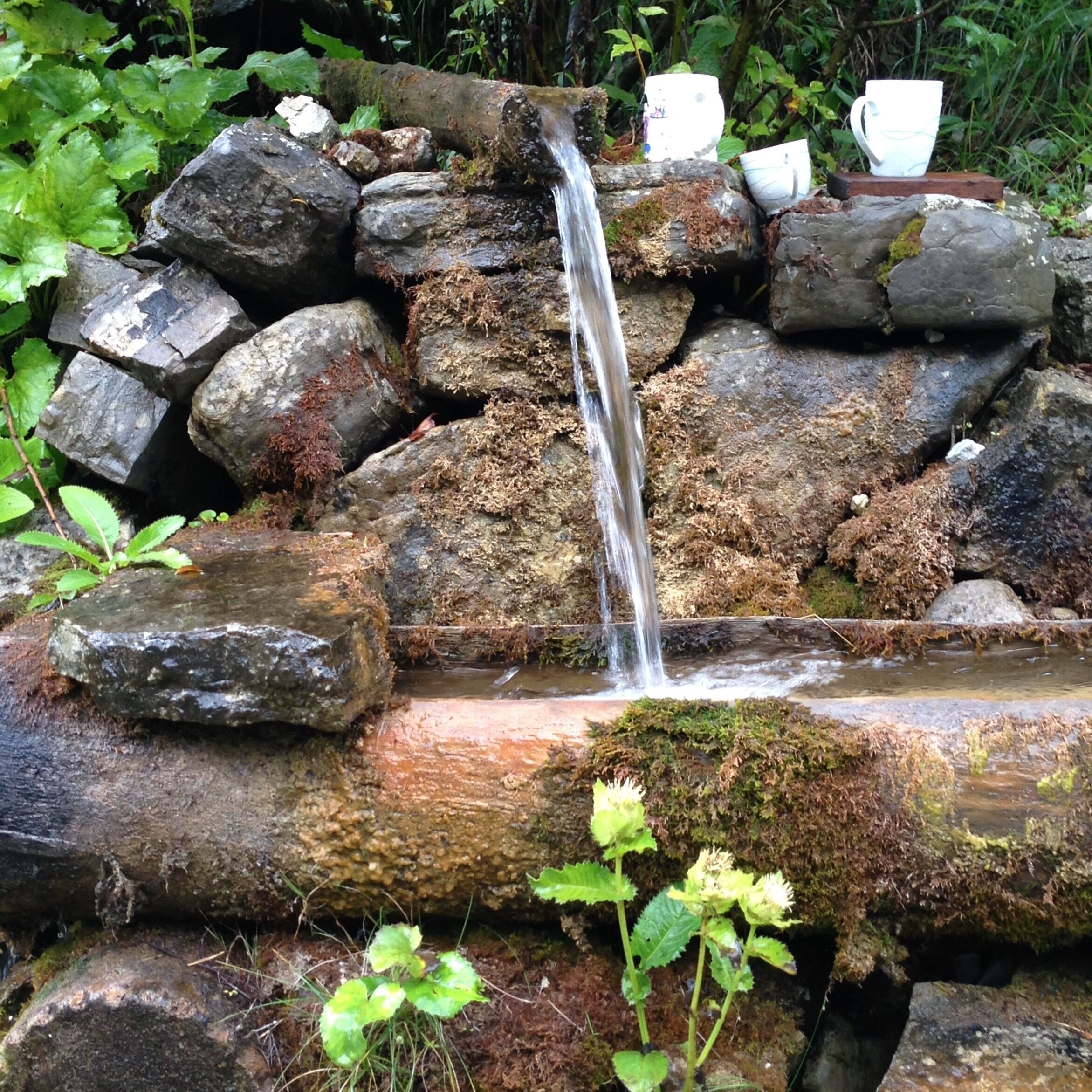 A small waterfall cascading over rocks in a garden.
