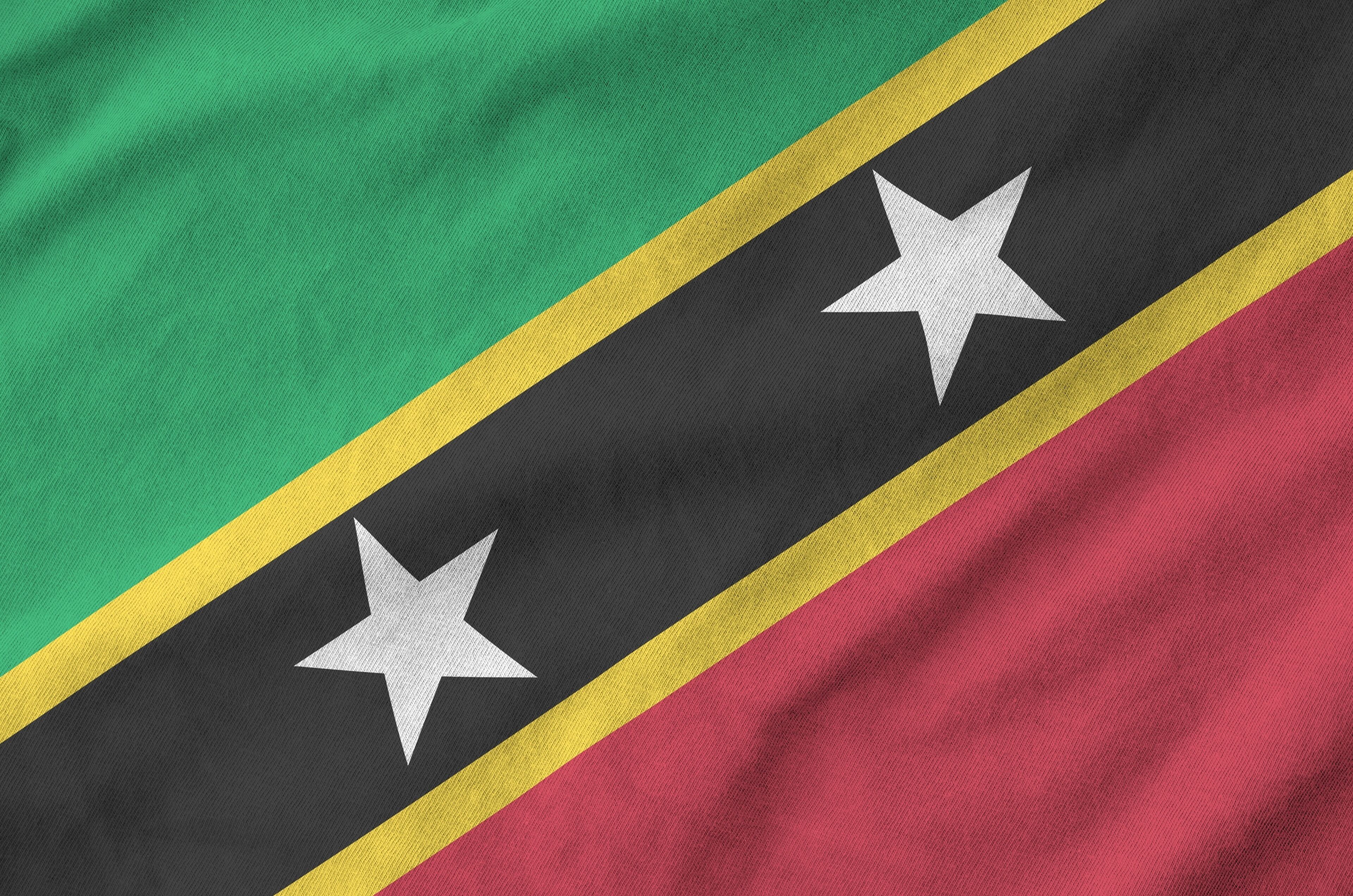 Uma bandeira com as cores verde, preto, amarelo e vermelho e duas estrelas brancas.