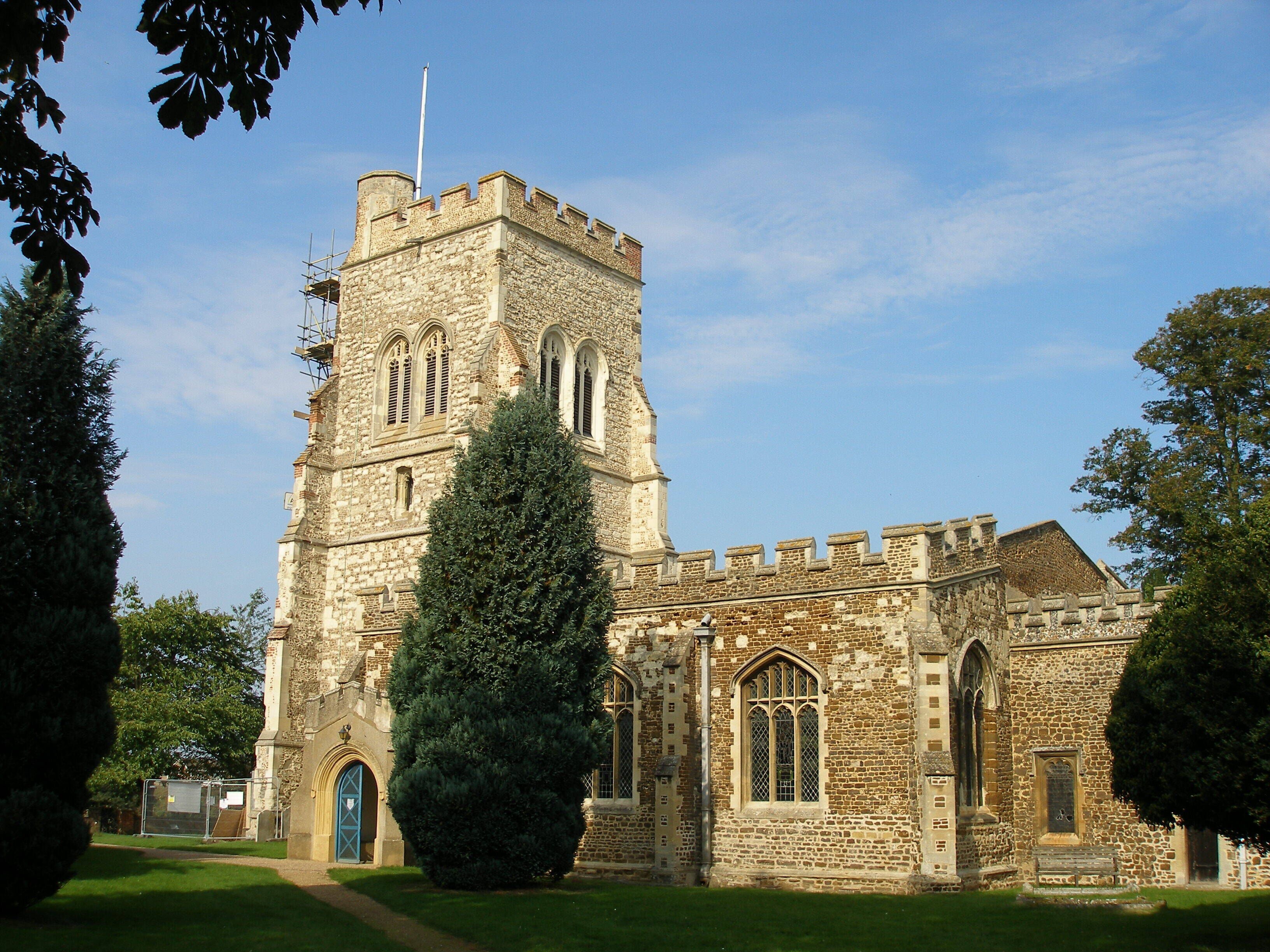 A historic stone church with a tall tower and arched windows.