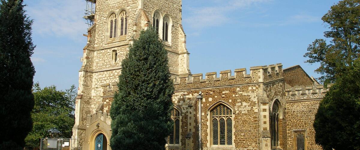 A historic stone church with a tall tower and arched windows.