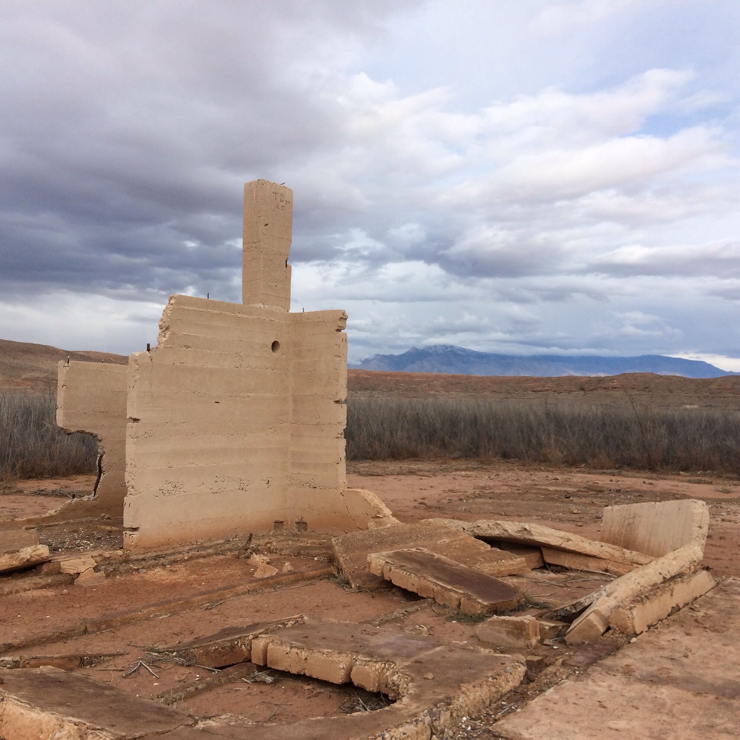 An ancient ruin with a tall, rectangular structure and a smaller building in the foreground.