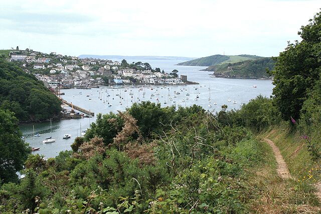 A coastal town with boats, a path, and greenery.