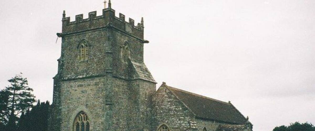 A historic stone church with a prominent tower and arched windows.