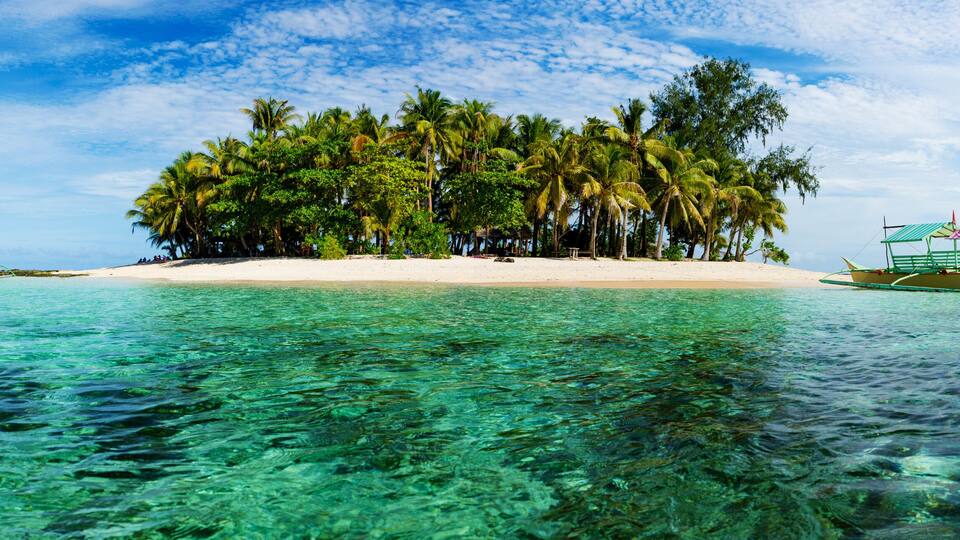 Tropical Guyam Island with traditional fishing boats