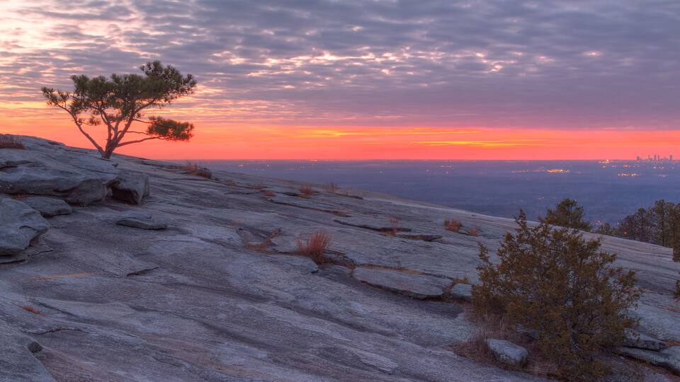 The beautiful view of the mountainside of Stone Mountain with pine tree and red horizon at sunset, Georgia, USA