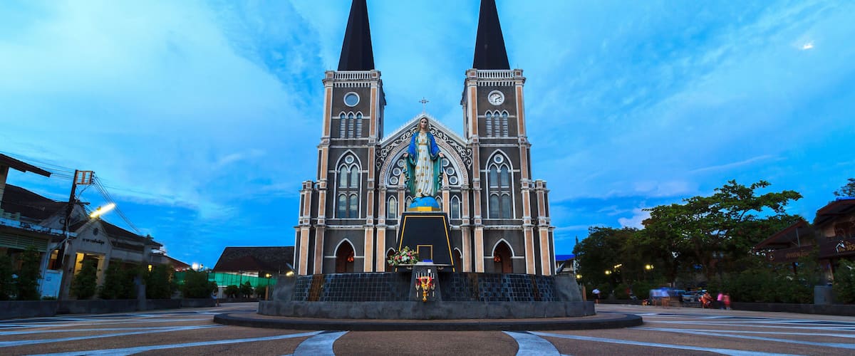 A large church with two tall spires and a central statue.