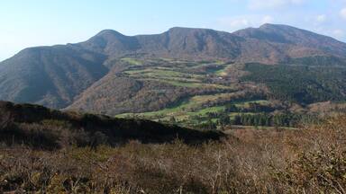 A mountainous landscape with rolling hills and scattered buildings.