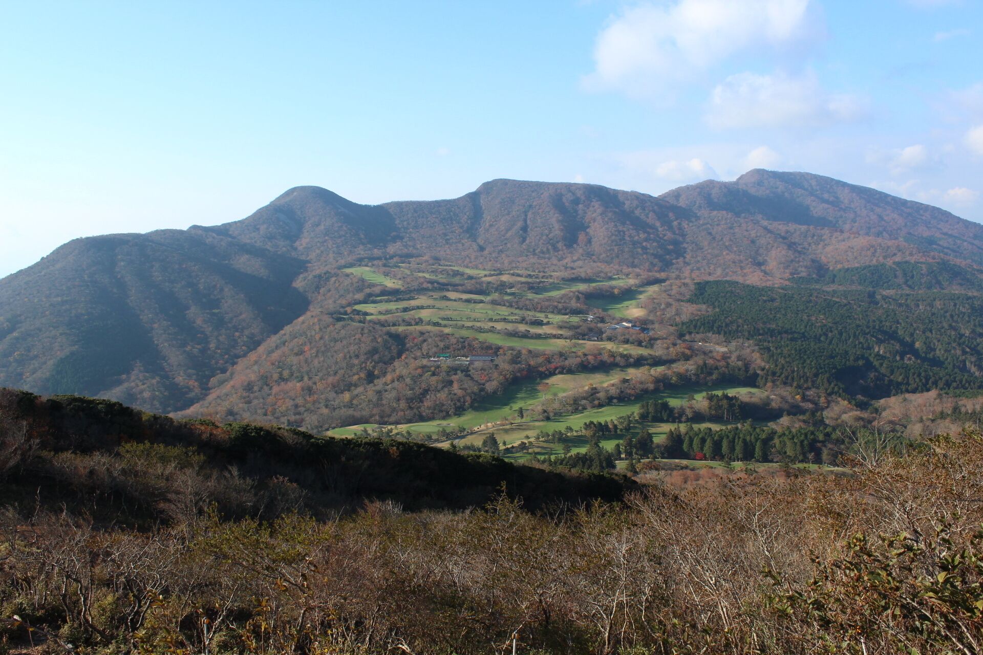 A mountainous landscape with rolling hills and scattered buildings.