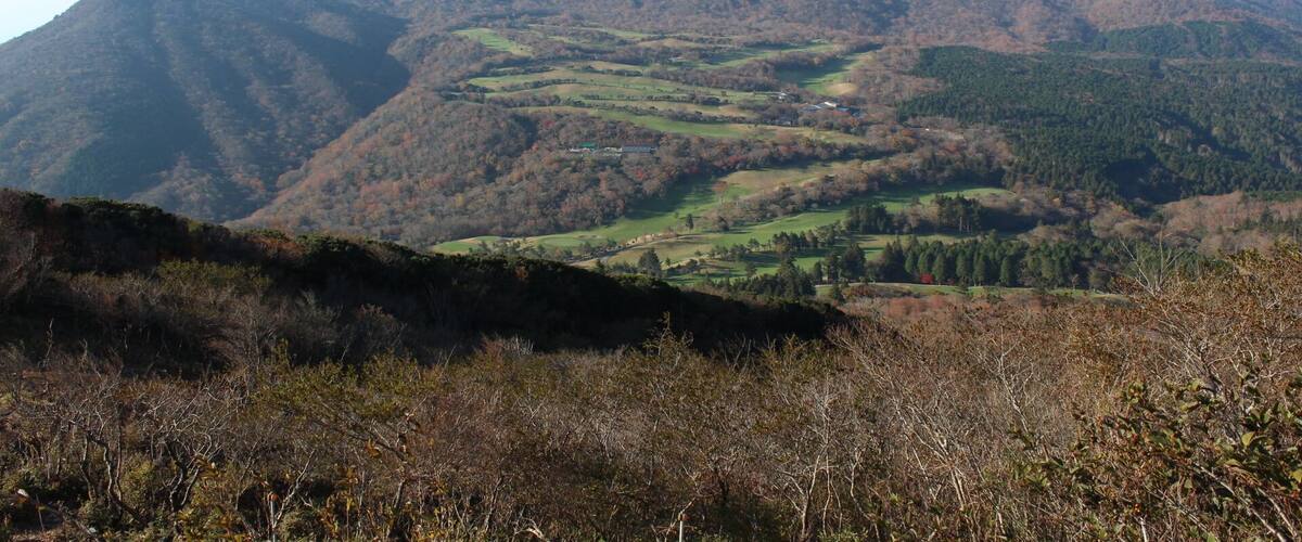 A mountainous landscape with rolling hills and scattered buildings.