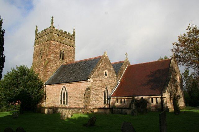 A historic church with a prominent tower and a red-roofed building.