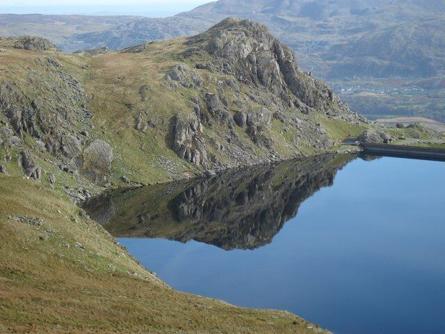 A mountain landscape with a clear lake reflecting the terrain.