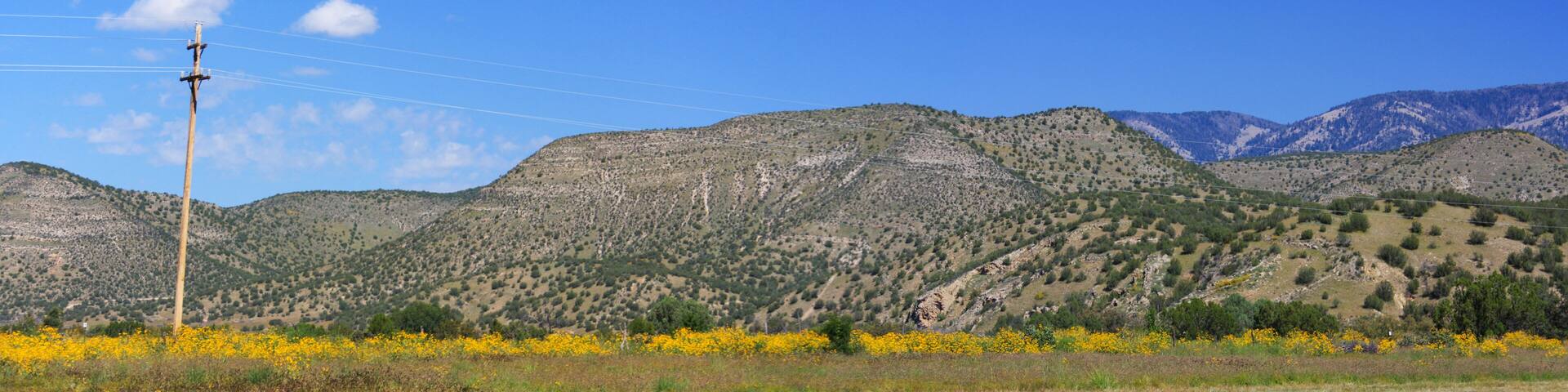 Landscape panorama in Lincoln County, New Mexico, USA. Famous in American Old West history for outlaw gunfighter known as Billy The Kid. Mountains, blue sky and old telegraph pole