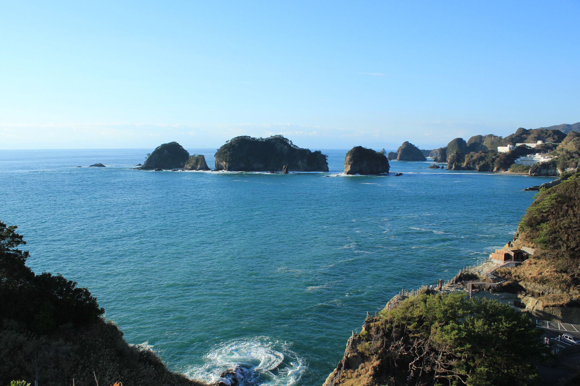 Dogashima coast with Sanshirojima (center) and the shack of outdoor hot spring of Sawada park (middle light), Nishiizu, Shizuoka prefecture, Japan.