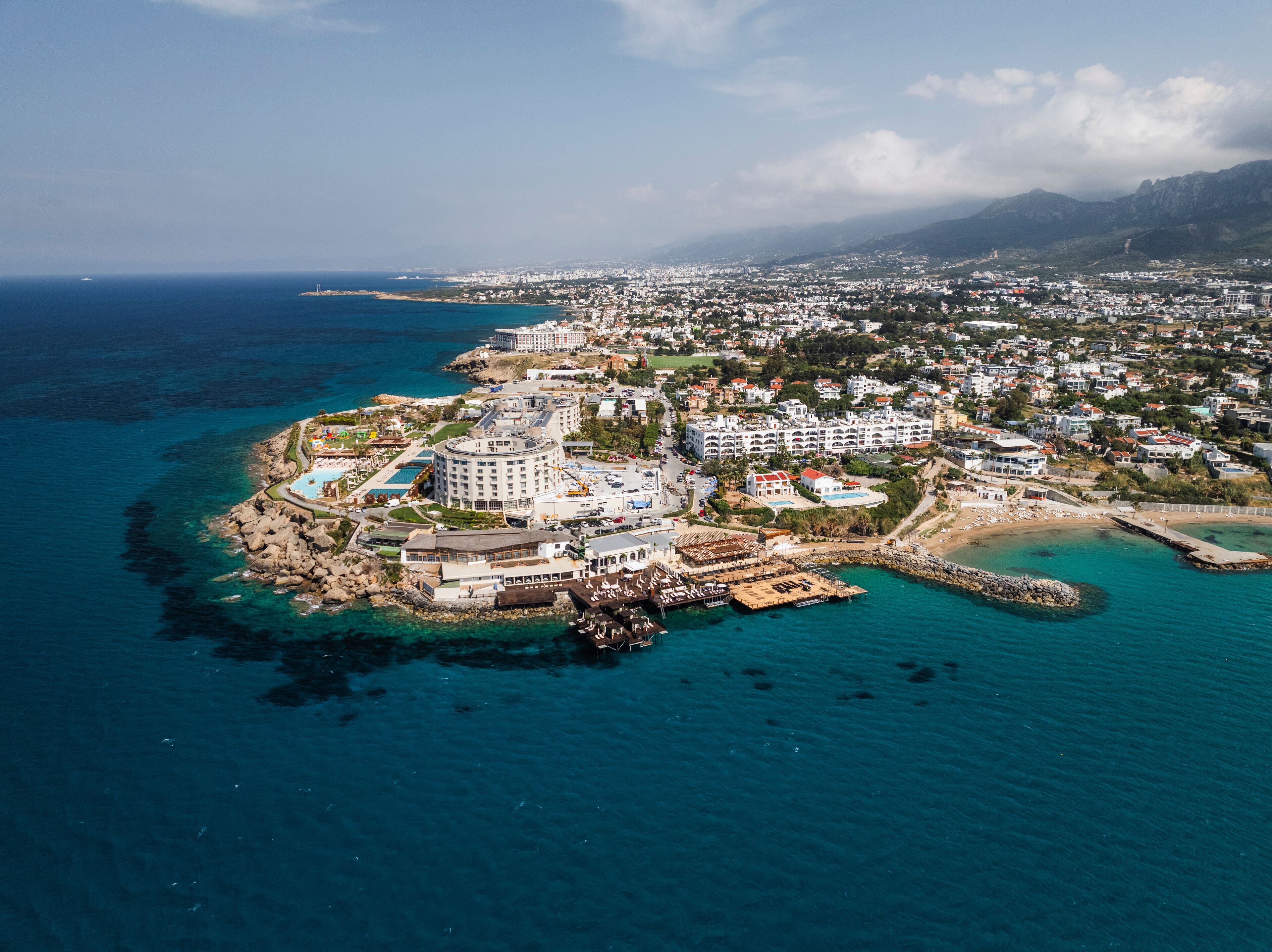 Aerial view of beautiful coastline with urban buildings and sandy beach, Agios Georgios Keryneias, Kyrenia, Turkish Republic of Northern Cyprus.