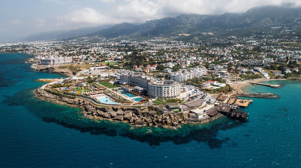Aerial view of beautiful coastline with clear water, buildings, and mountains, Agios Georgios Keryneias, Kyrenia, Turkish Republic of Northern Cyprus.