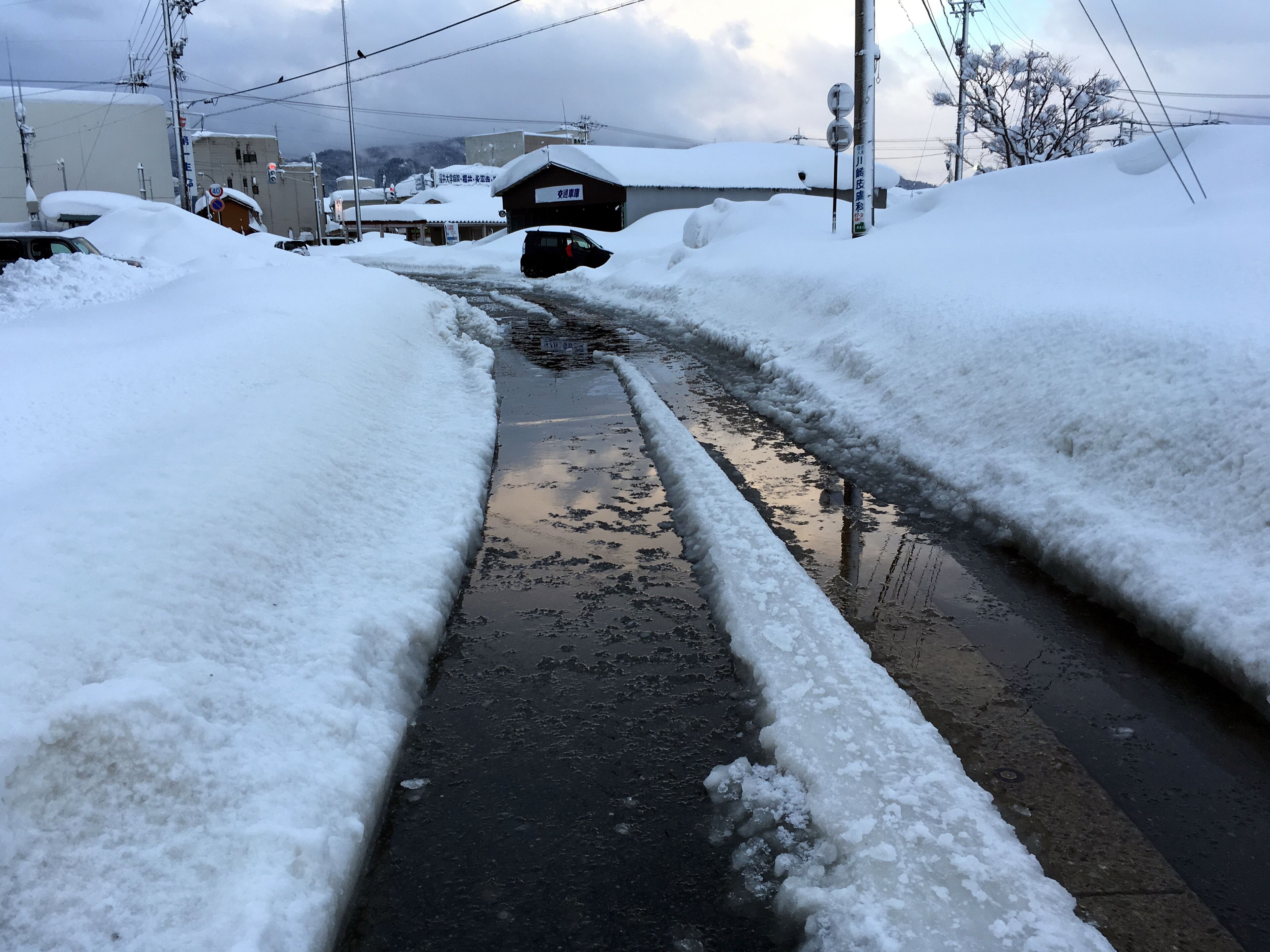 積雪で融雪装置の水はけが悪くなり冠水した道路（福井県坂井市）