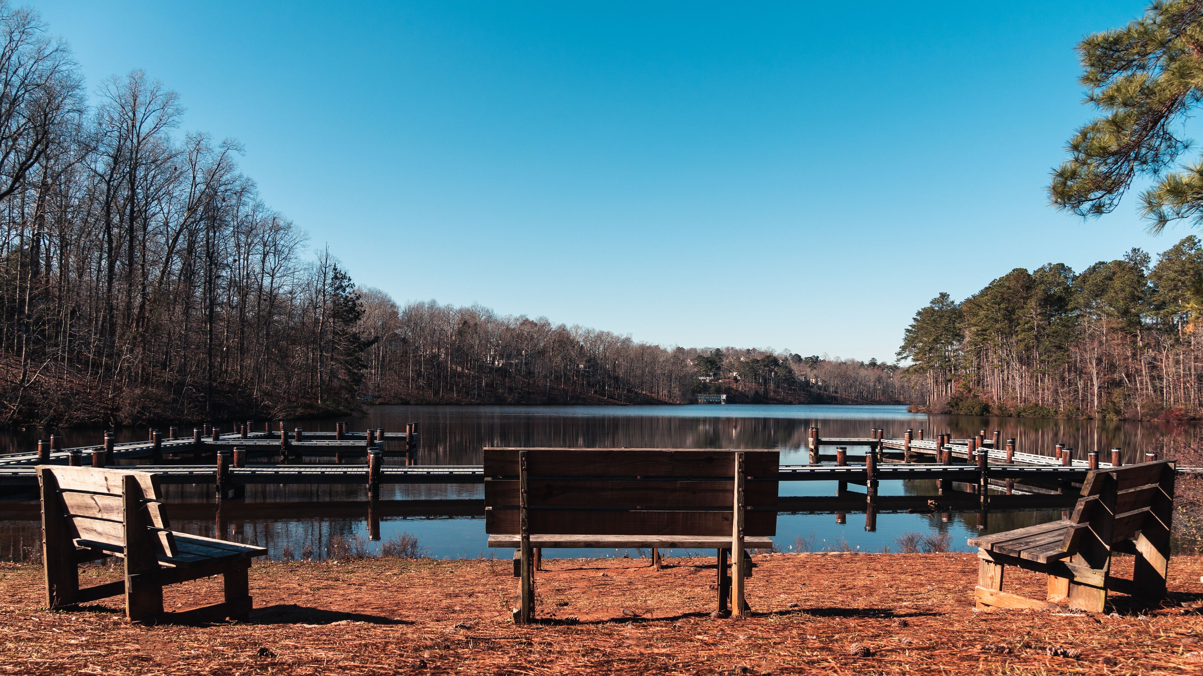 A lakeside park with wooden benches and docks.