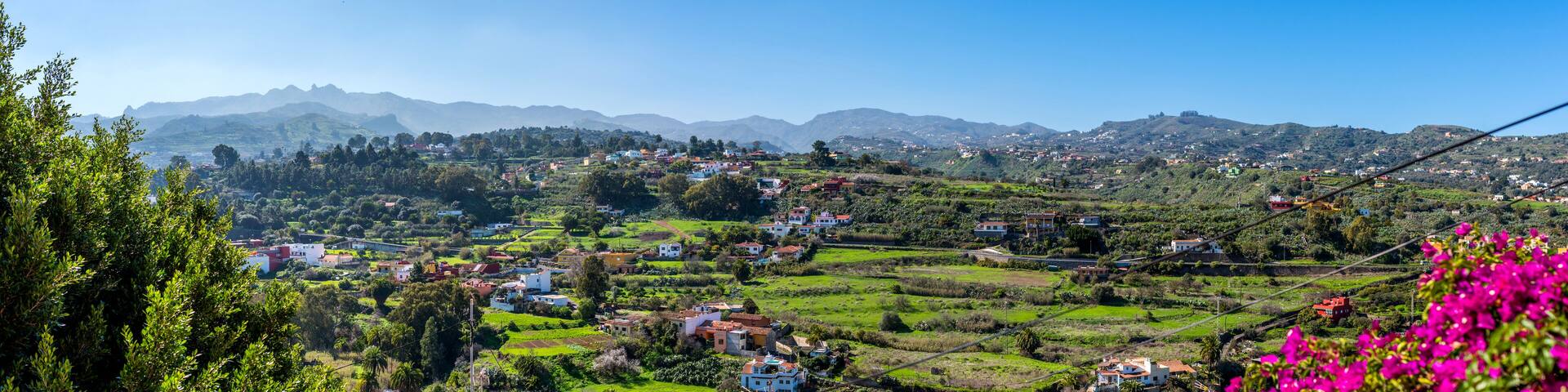 A mountainous landscape with scattered houses and lush greenery.