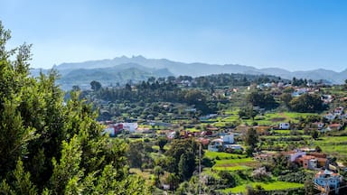 Paisagem montanhosa com casas dispersas e vegetação exuberante.
