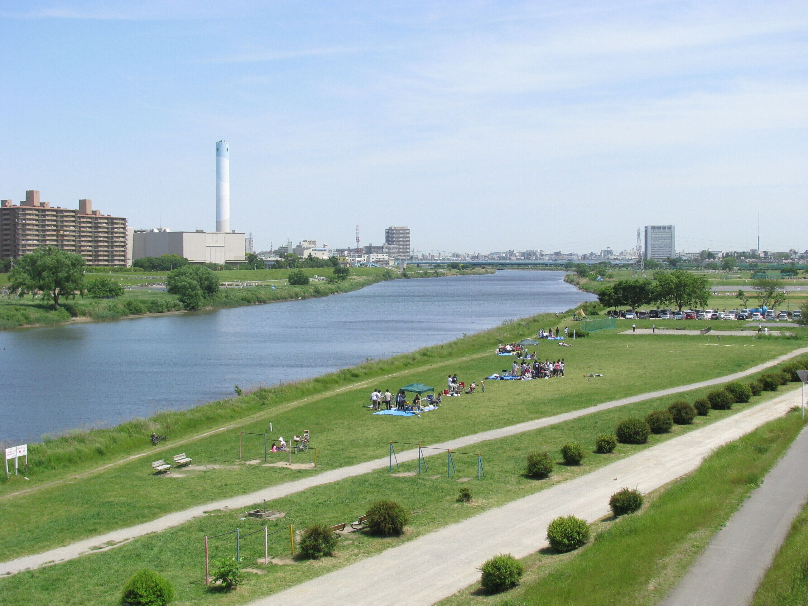 A river with a park and playgrounds along the banks.