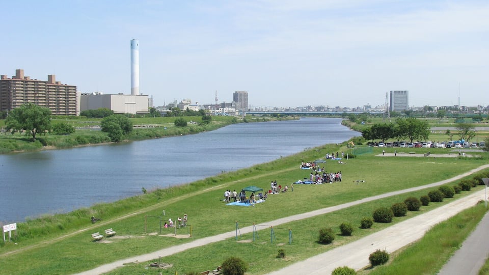 A river with a park and playgrounds along the banks.