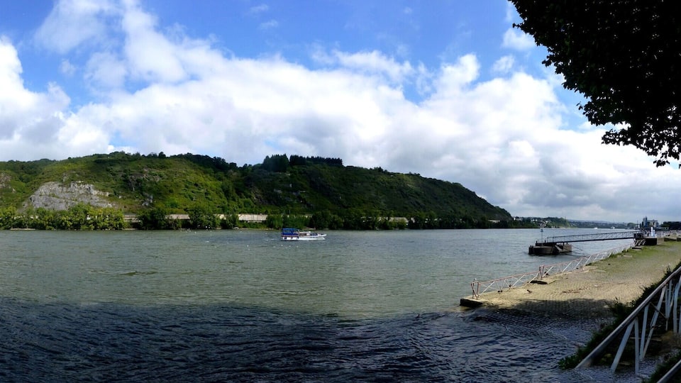 A river with boats, a bridge, and a forested island.