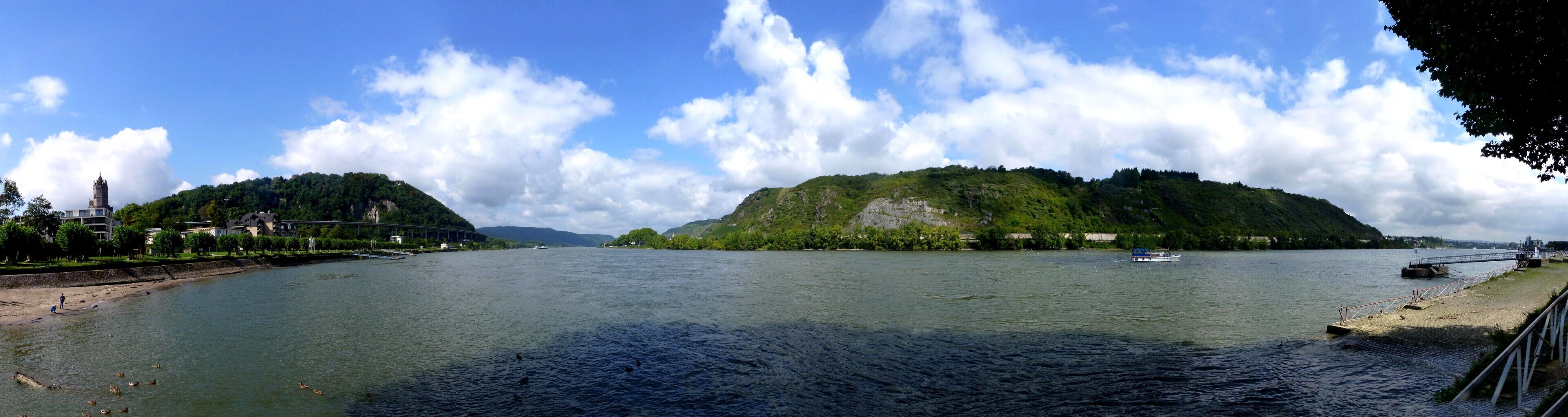 A river with boats, a bridge, and a forested island.