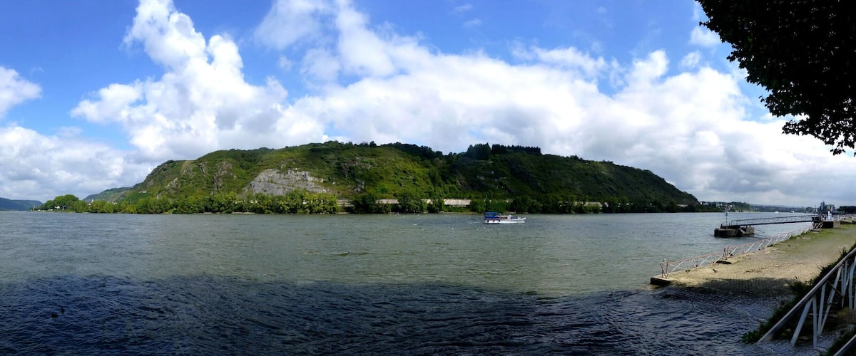 A river with boats, a bridge, and a forested island.