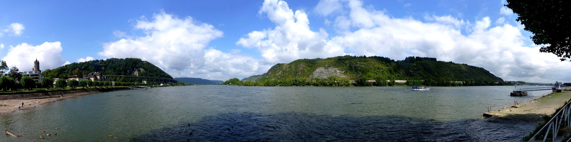 A river with boats, a bridge, and a forested island.