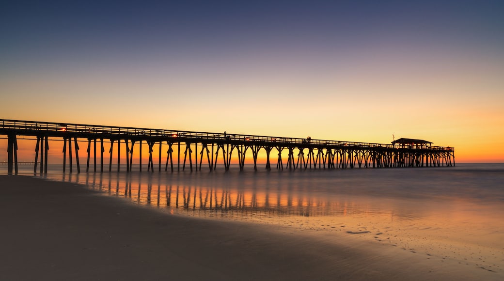 A pier extending into calm waters at sunset.