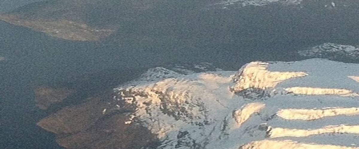 A snow-covered mountain range with rugged terrain and a valley.