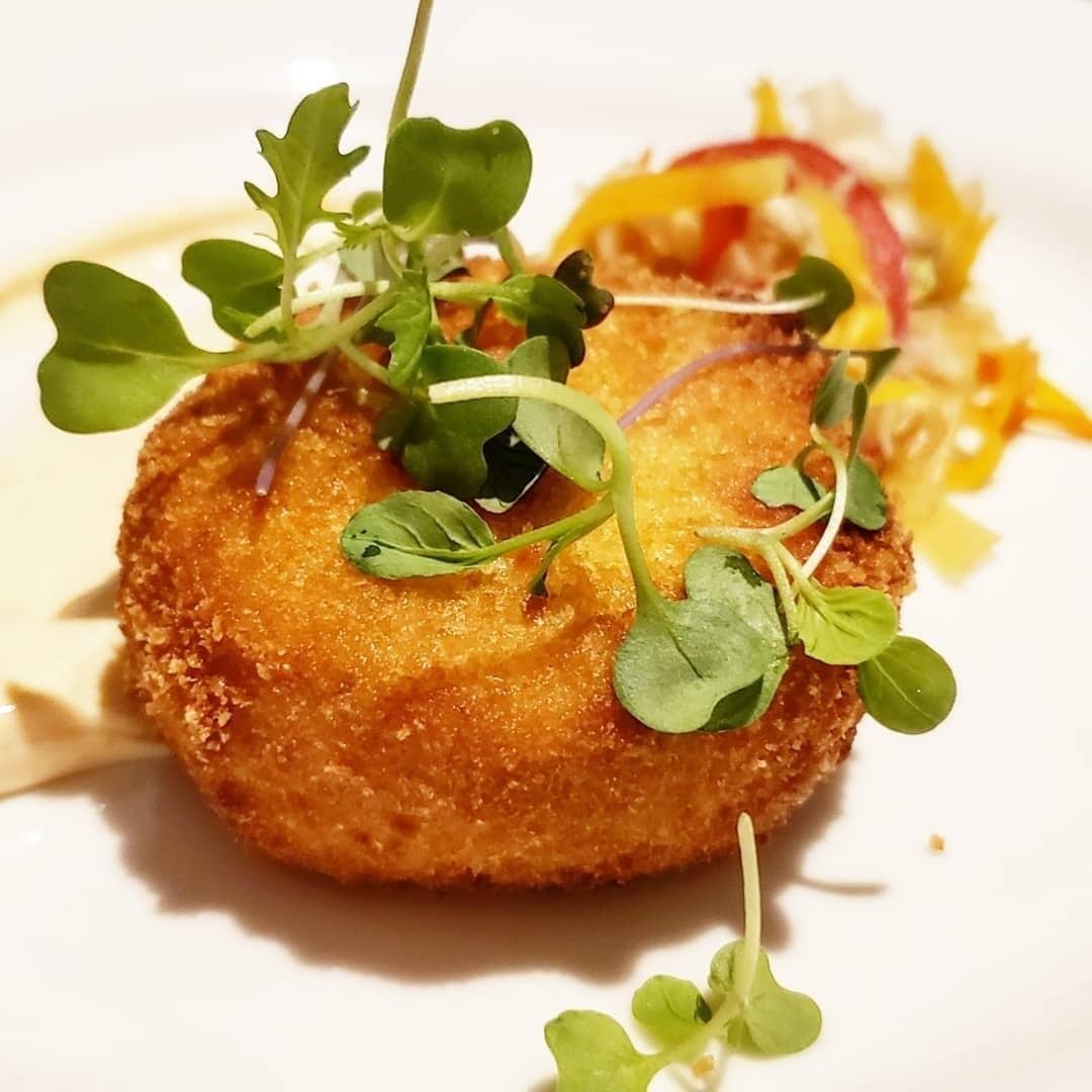Un plato con corteza dorada, adornado con pequeñas hojas verdes.