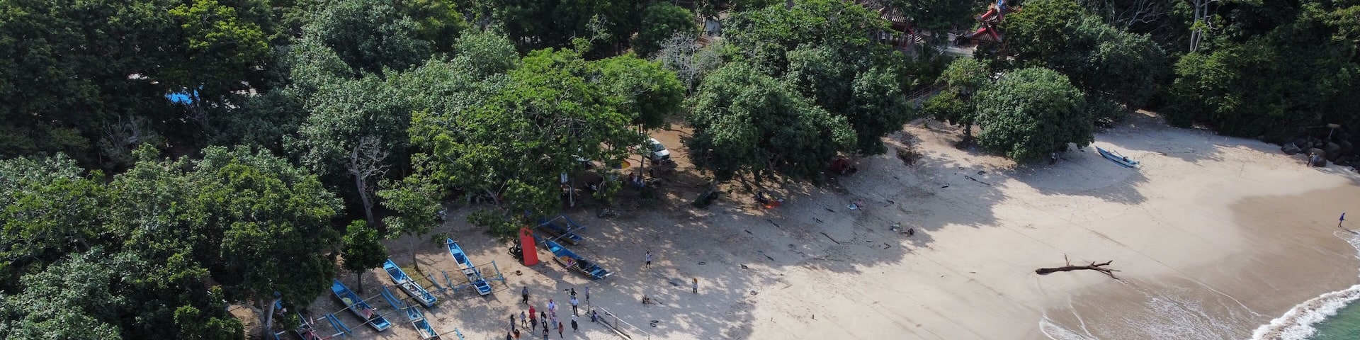 Aerial view of fishing boats and people at Tanjung Papuma Beach