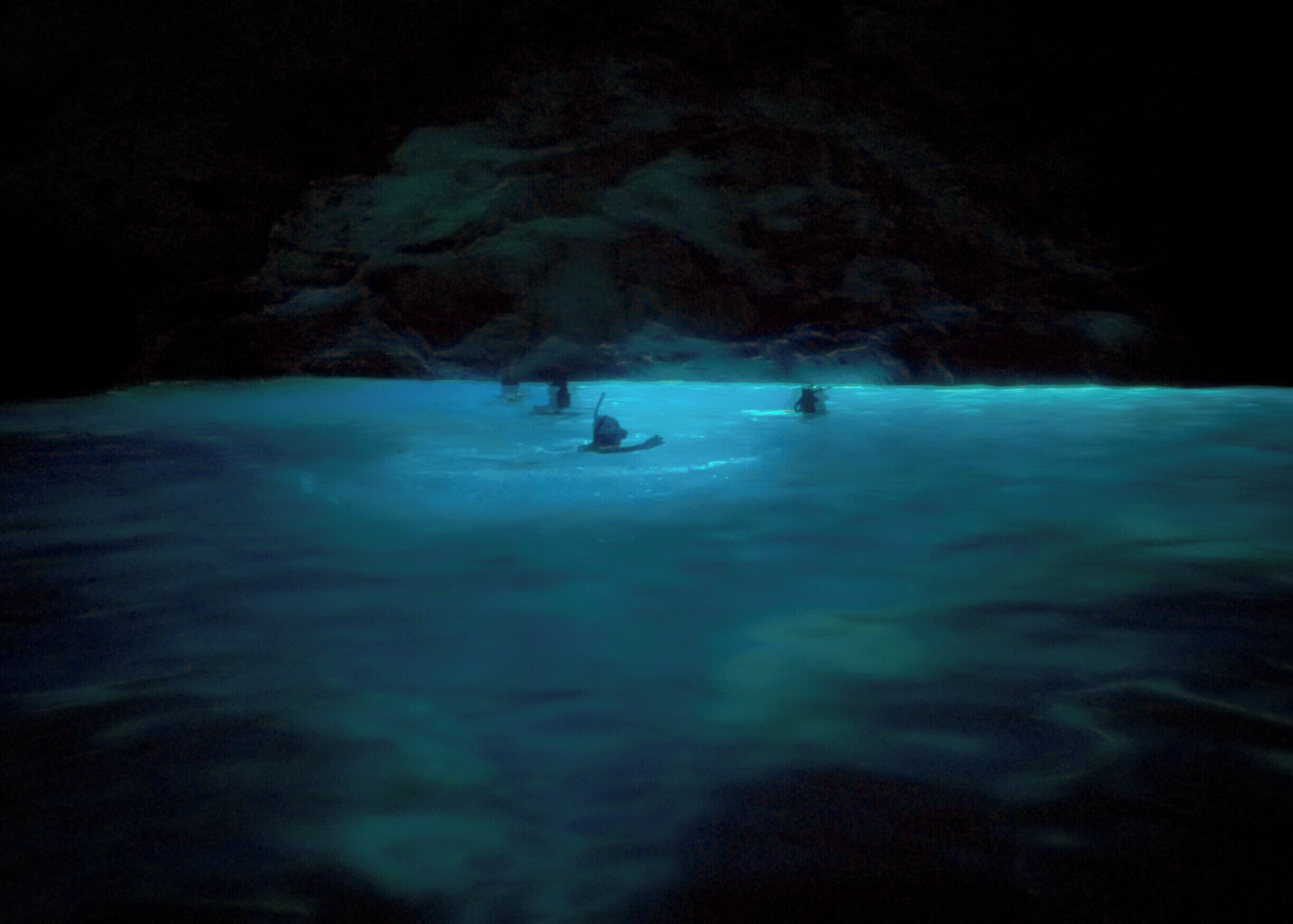 A cave entrance with water reflecting light.