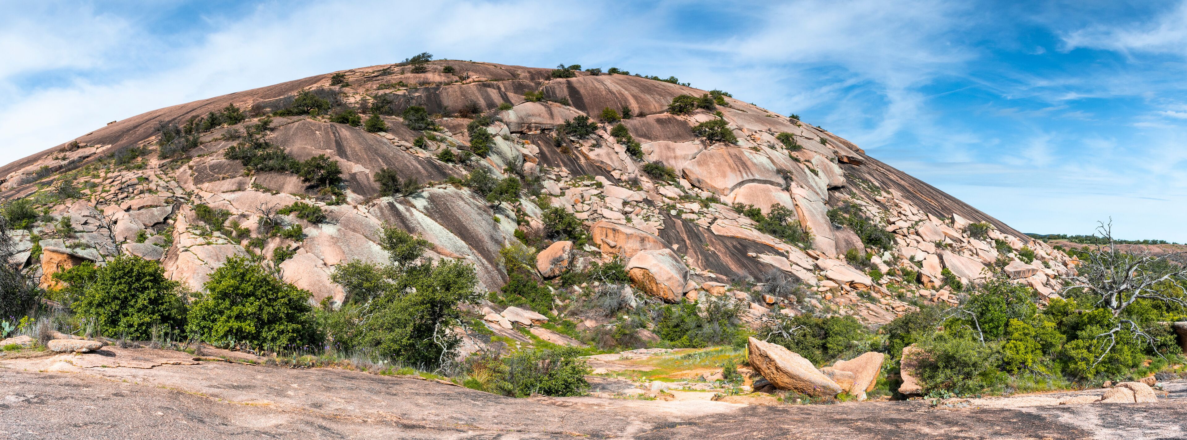 A large, rugged mountain with sparse vegetation and rocky outcrops.