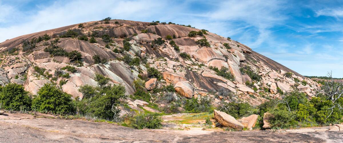 A large, rugged mountain with sparse vegetation and rocky outcrops.
