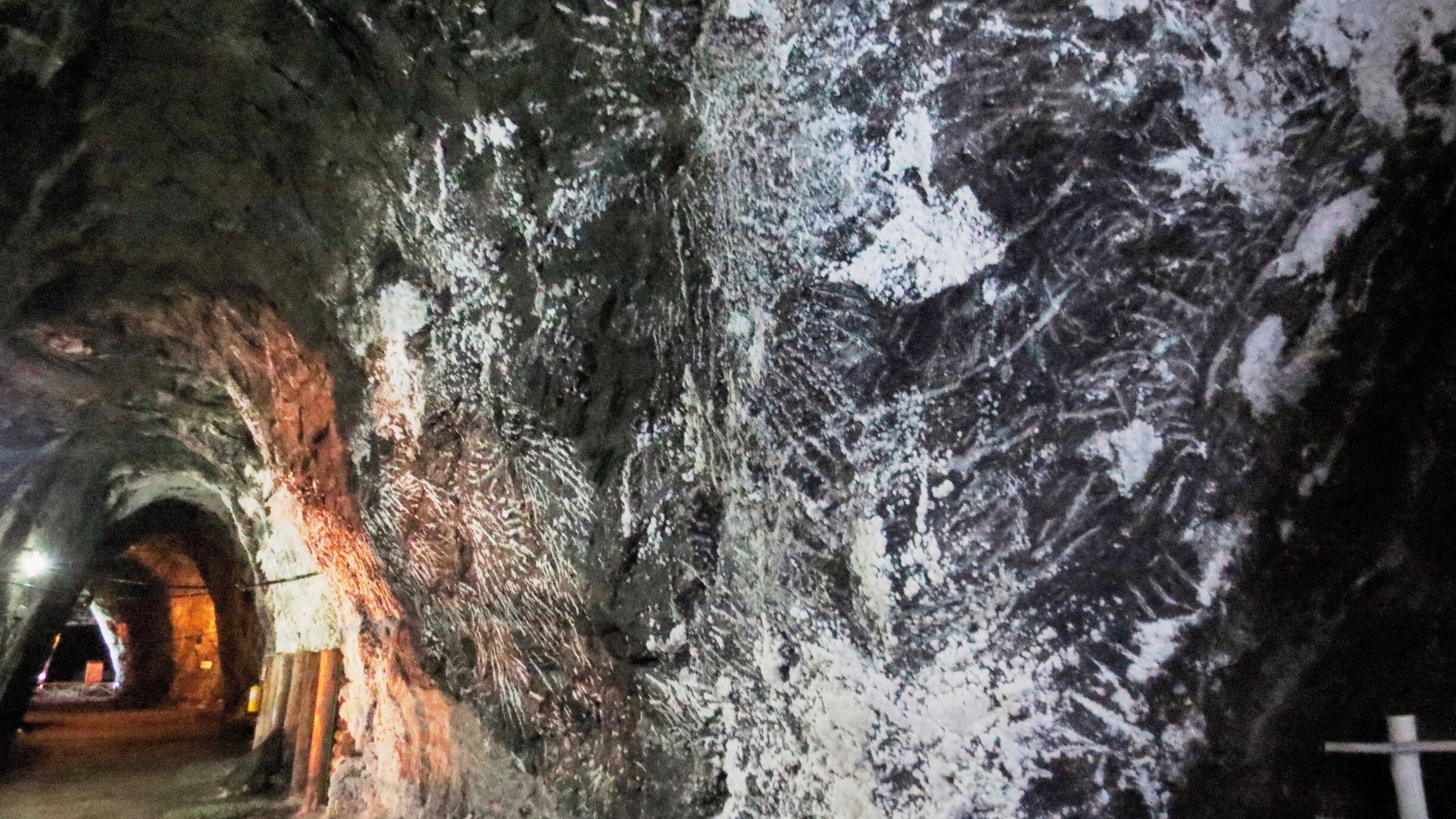A cave with a tunnel and a large rock face.